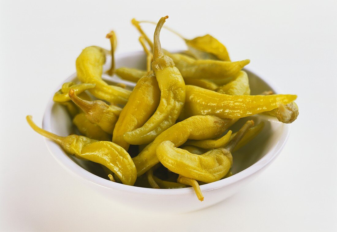 Green, bottled chili peppers in a dish