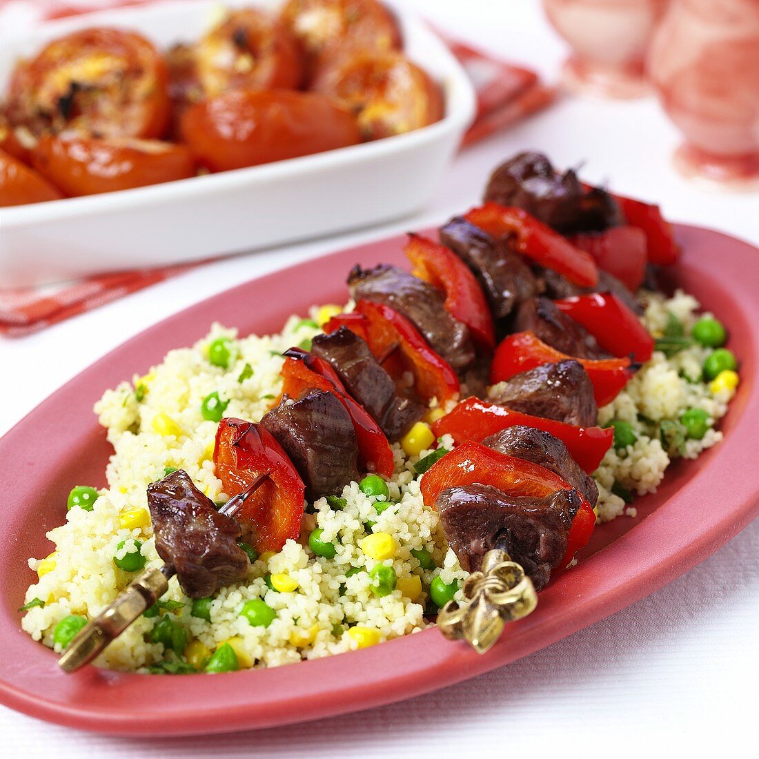 Lamm-Paprika-Spiesse auf Couscous mit Erbsen und Mais