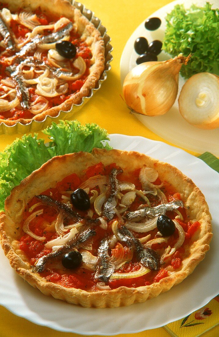 Pizza mit Tomaten, Zwiebeln, Anchovis und Oliven