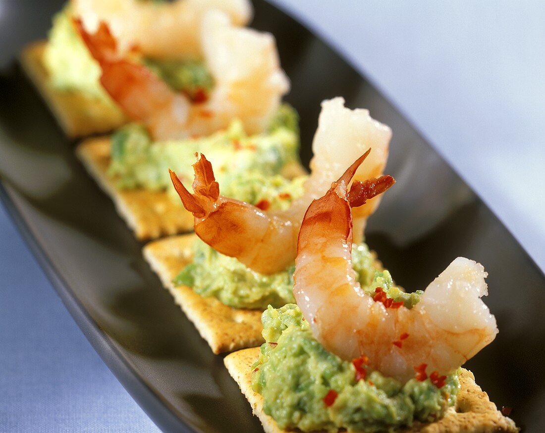 Cracker with avocado puree and shrimp tails