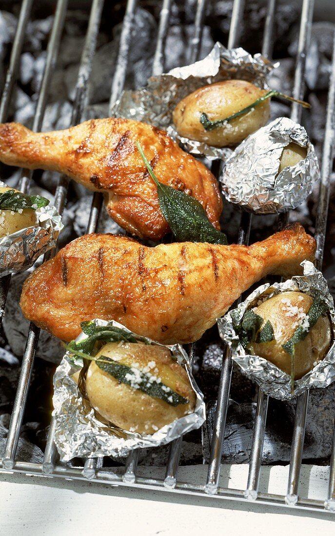Chicken legs with honey marinade and sage potatoes on barbecue