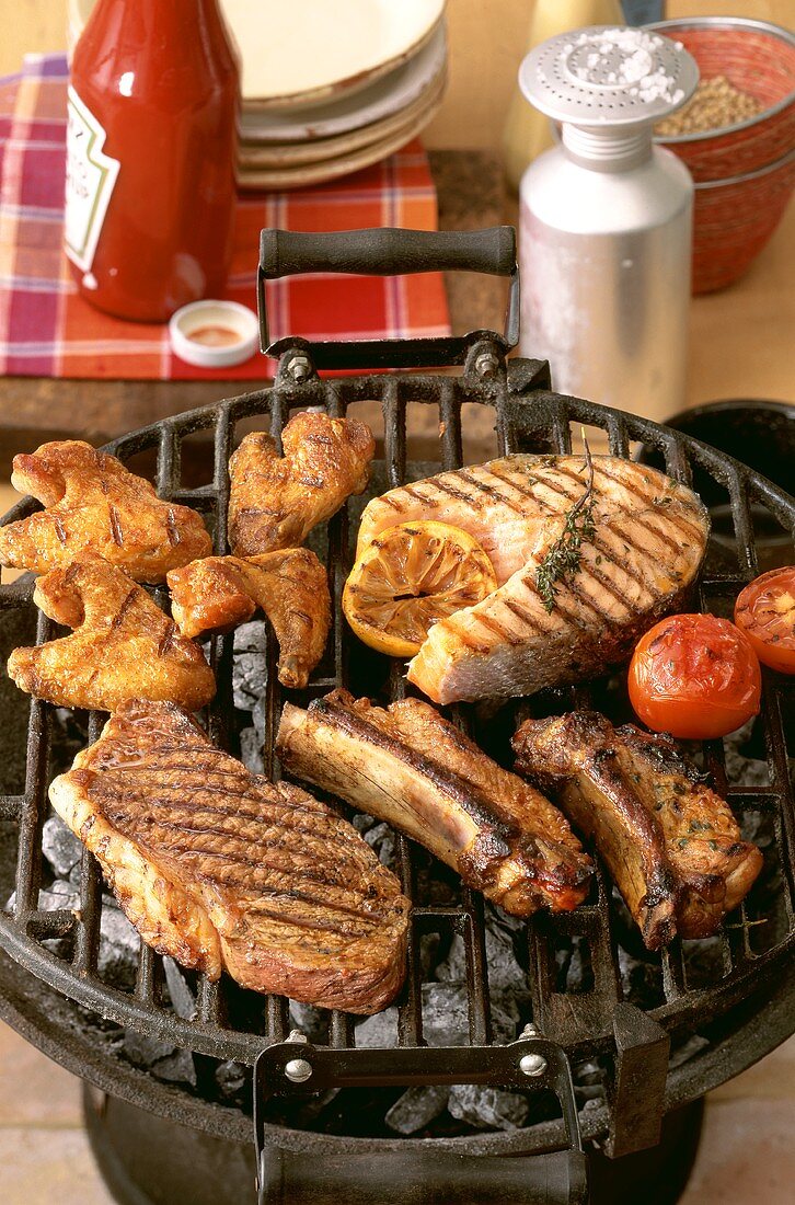 Steak, spare-ribs, salmon cutlet and chicken wings on barbecue