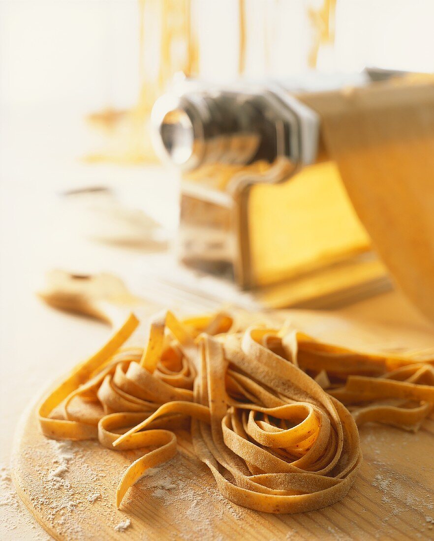 Home-made wholemeal tagliatelle in front of pasta maker