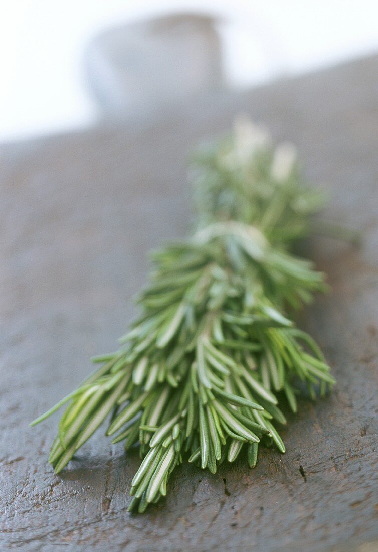 Sprigs of rosemary on a black wooden board