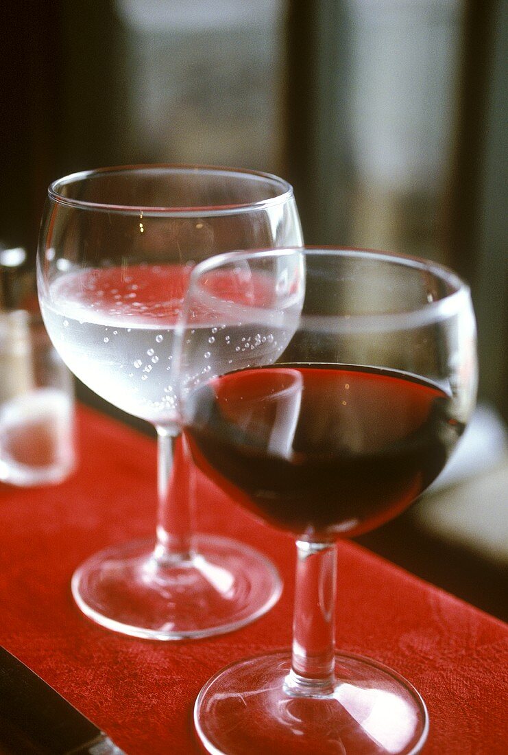 Glas Rotwein und Glas Wasser