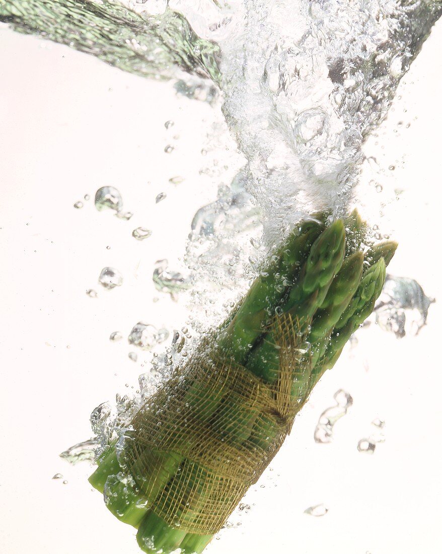 Bundle of green asparagus immersed in water