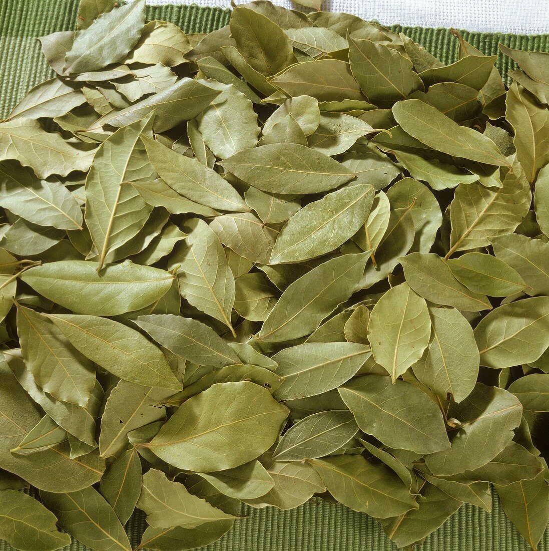 Dried bay leaves on green place-mat