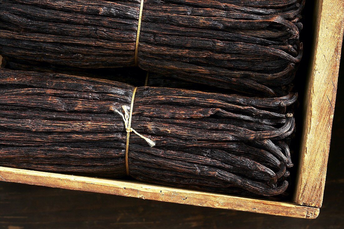 Bundles of vanilla pods in a wooden crate