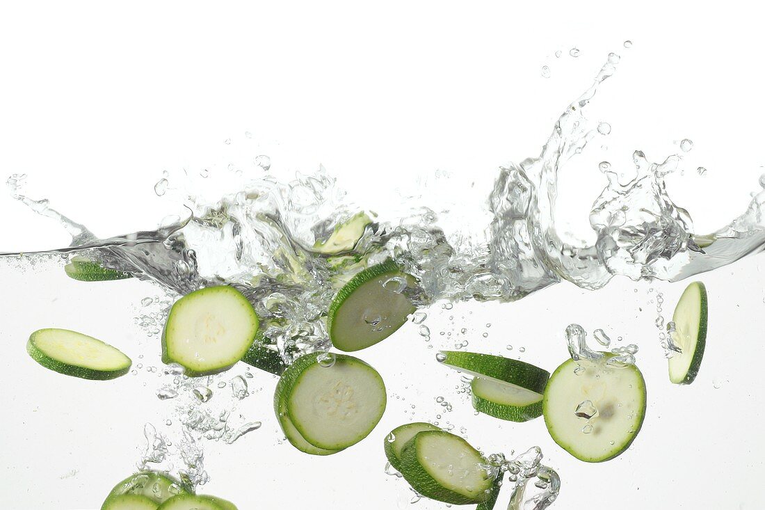 Courgette slices falling into water