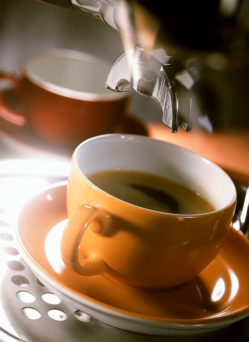 Tasse Kaffee unter einer Kaffeemaschine