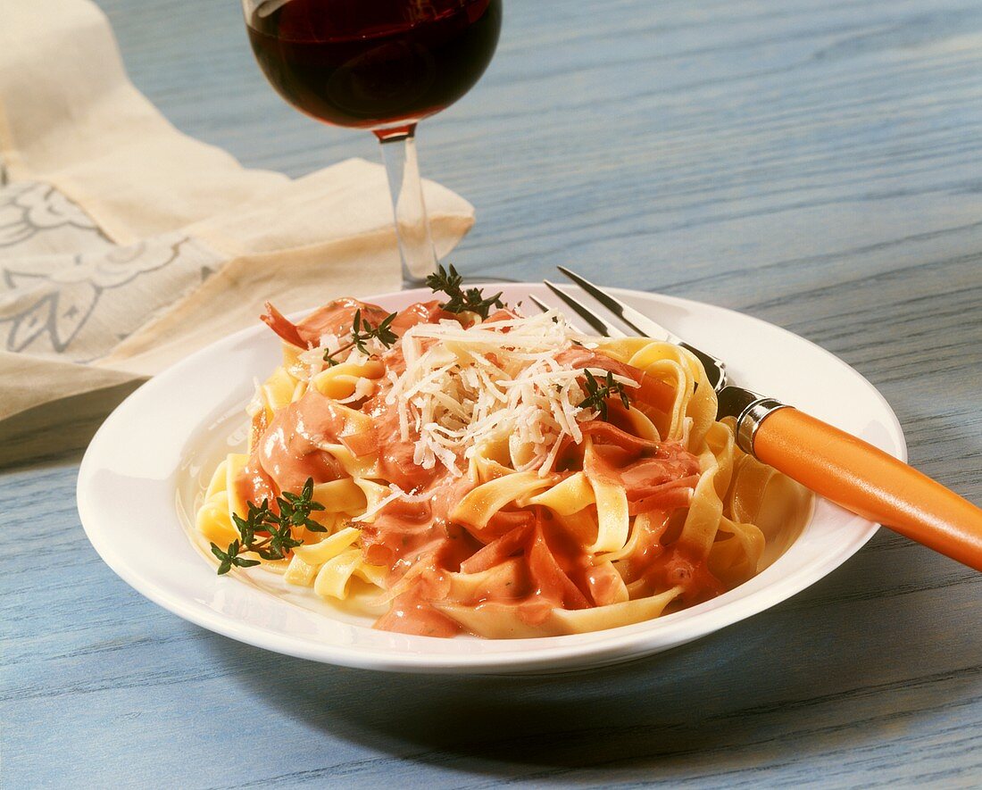 Fettuccine with fruity tomato sauce and ham; red wine