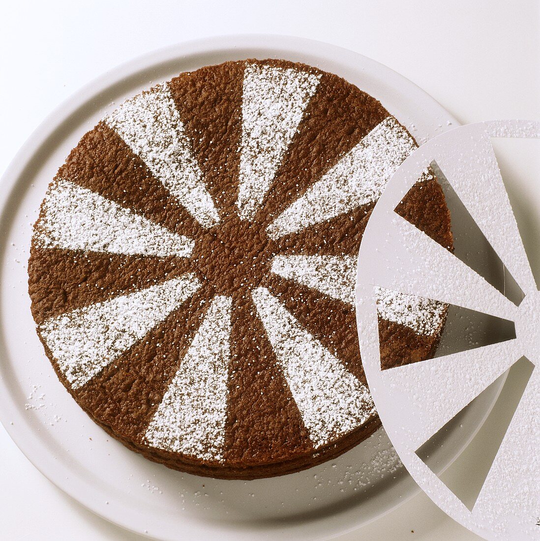 Decorating chocolate cake with icing sugar