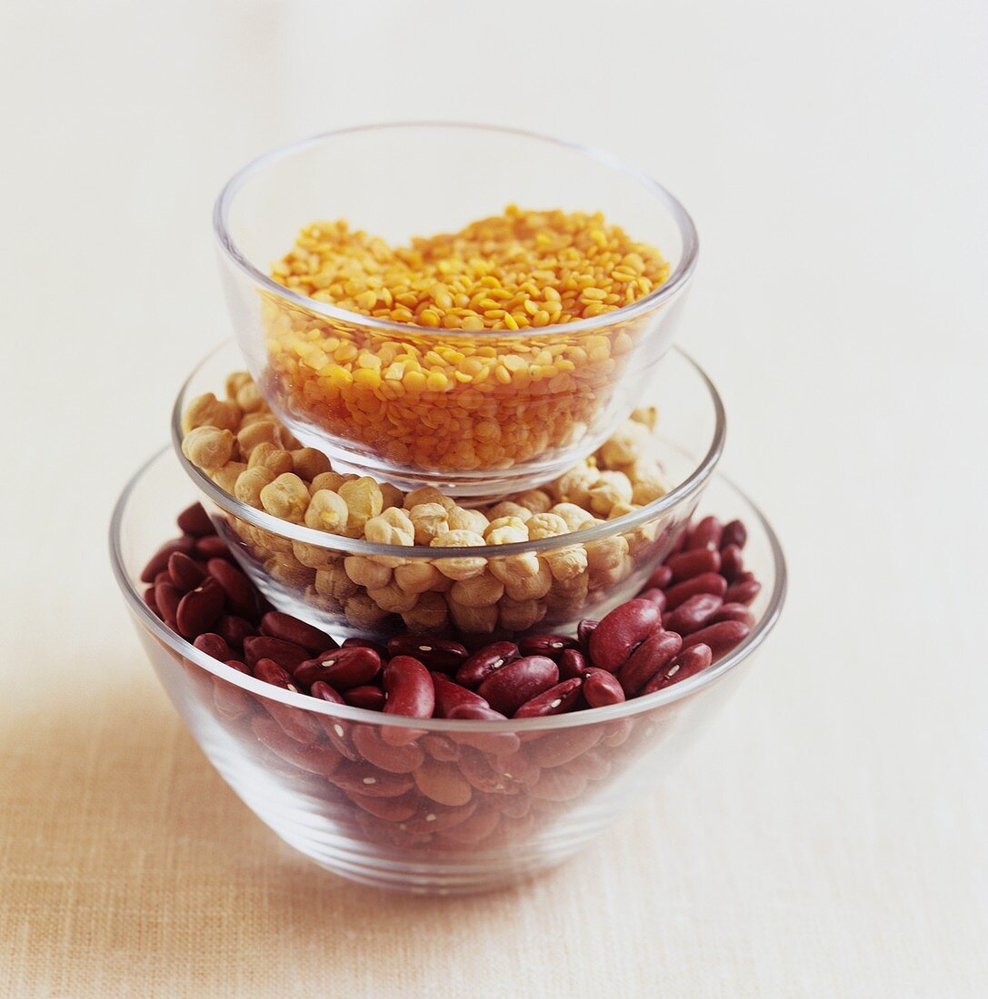 Red lentils, chick-peas and kidney beans in glass bowls