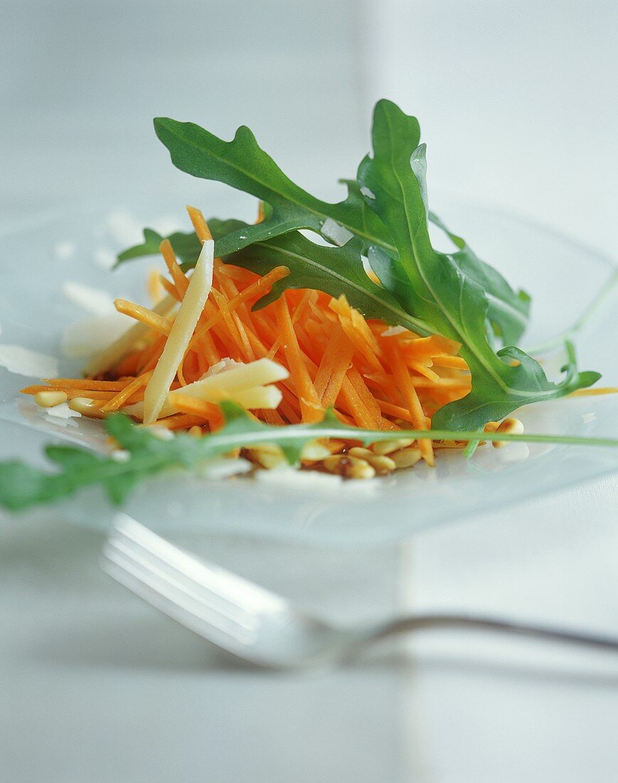 Raw carrot salad with rocket, cheese and pine nuts