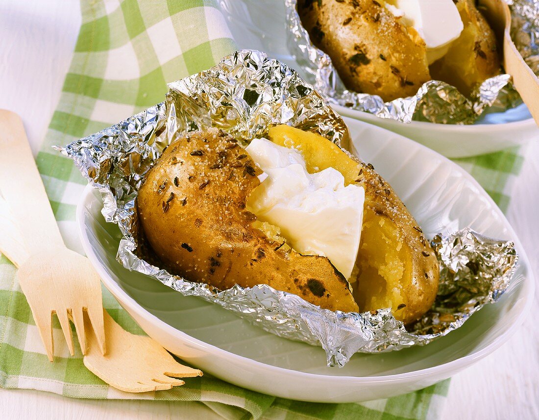 Baked potato in foil with sour cream