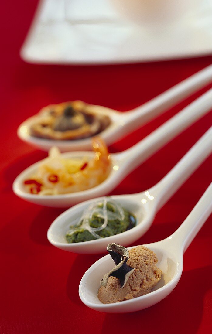 Assorted savoury snacks served on porcelain spoons