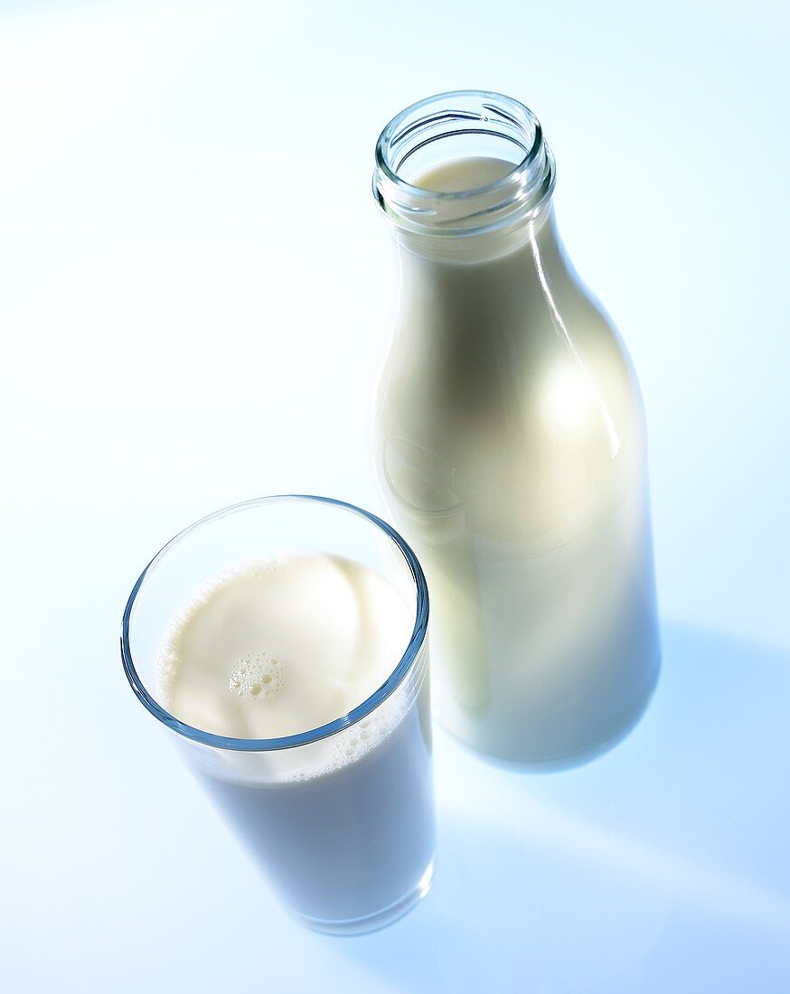 A glass and a bottle of milk