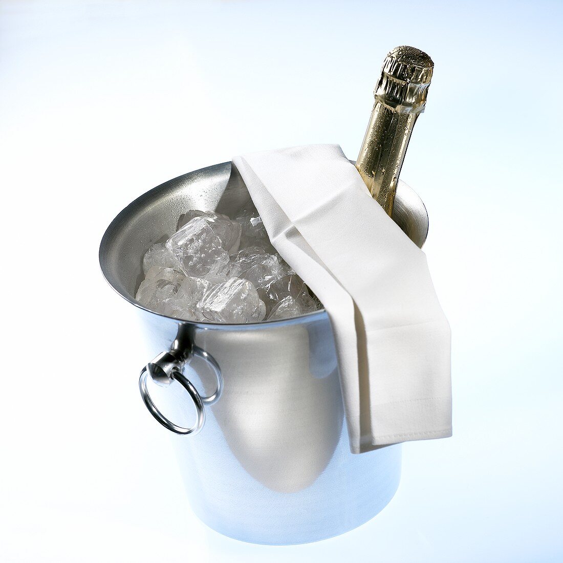 Bottle of champagne in champagne cooler with ice cubes