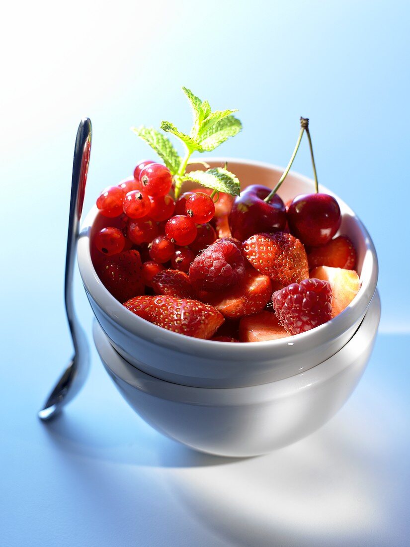 Berry salad with cherries in small bowl