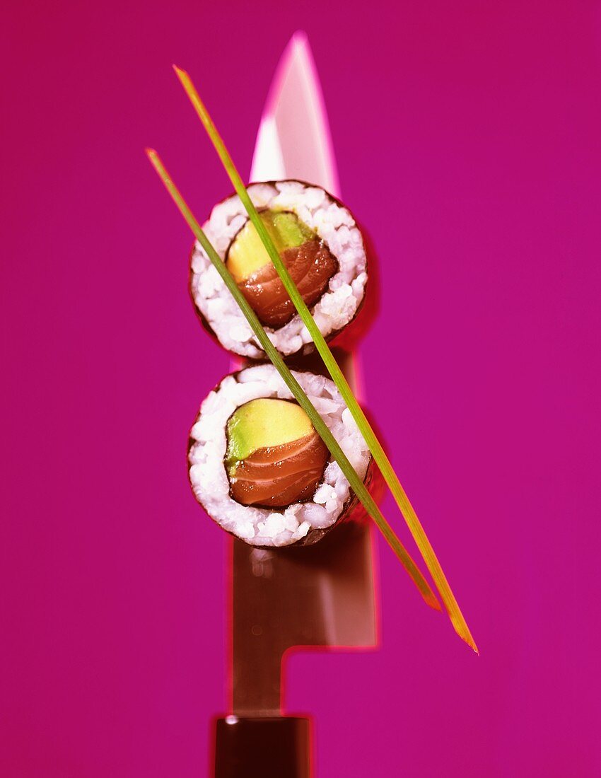 Zwei Maki-Sushi mit Avocado und Lachs auf Messer