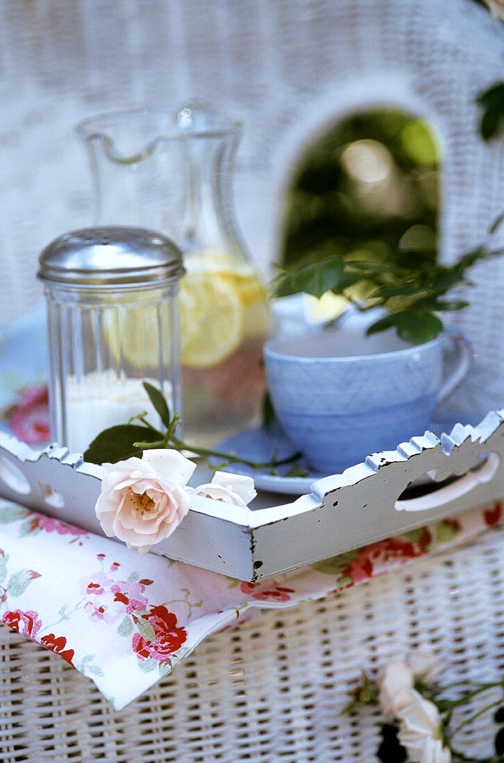 Tray with cup and lemonade on a wicker chair