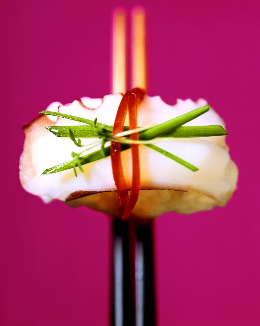 Nigiri-Sushi mit Tintenfisch auf Essstäbchen