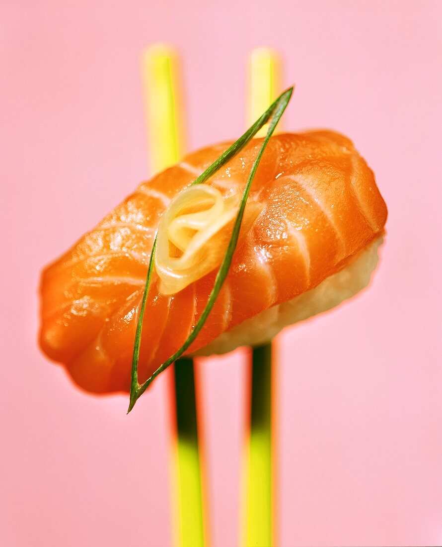 Nigiri-sushi with salmon on chopsticks