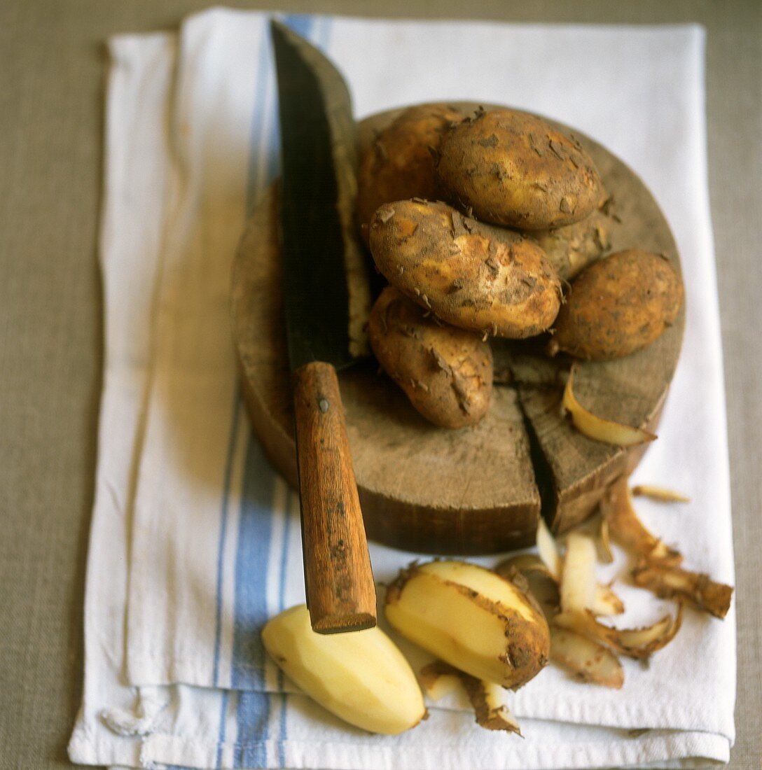 Stillleben mit geschälten und ungeschälten Kartoffeln