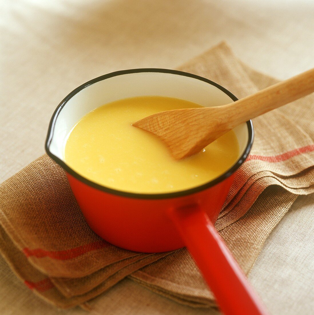Custard with kitchen spoon in a pan