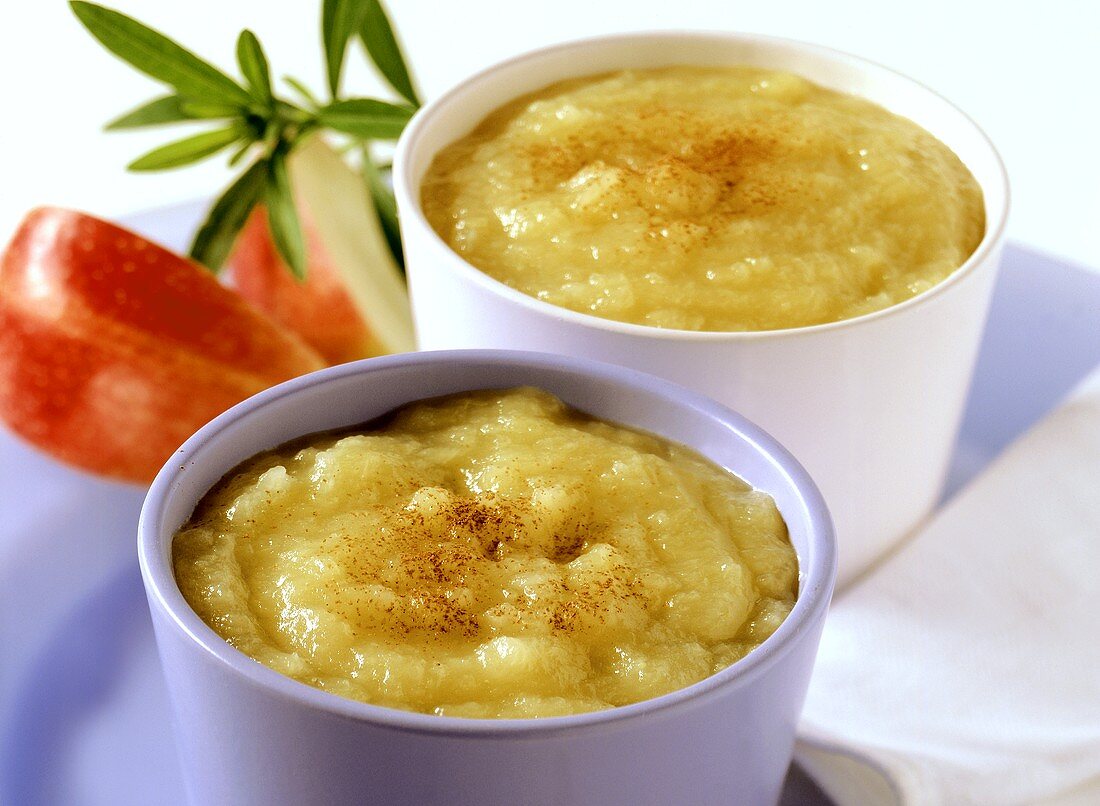 Two bowls of apple puree with ground cinnamon