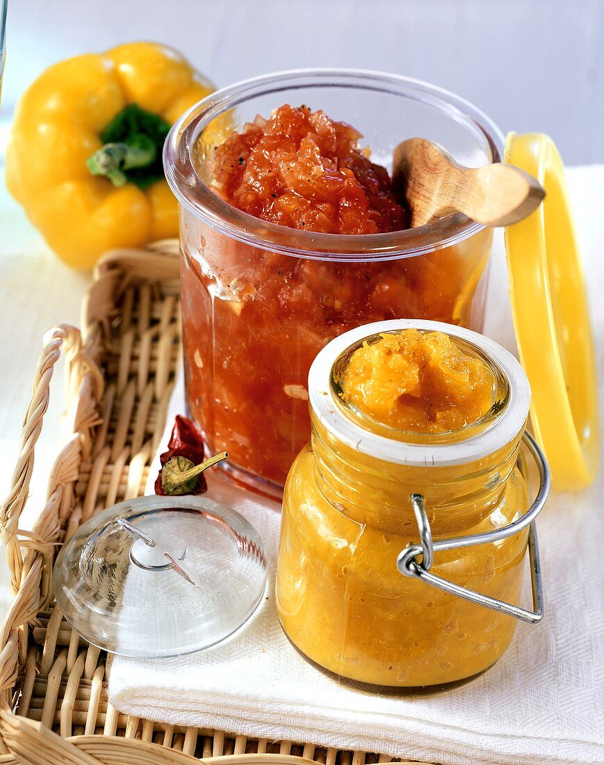 Gelbe Paprika-Curry-Sauce und rote Hot-Chili-Sauce in Gläsern