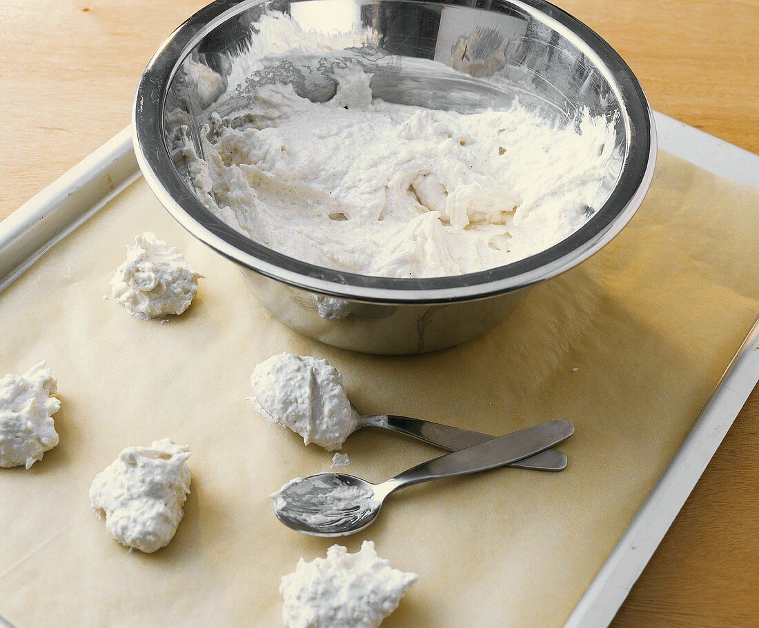 Macaroon mixture in bowl and on baking tray