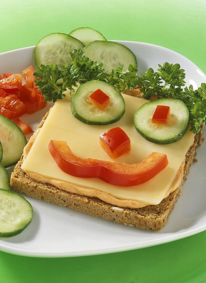 Amusing wholemeal toast with Butterkäse cheese & vegetable face