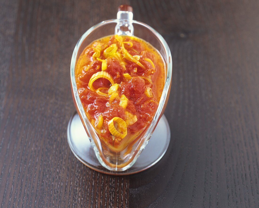 Safran-Tomaten-Sauce mit Zwiebelringen in Sauciere