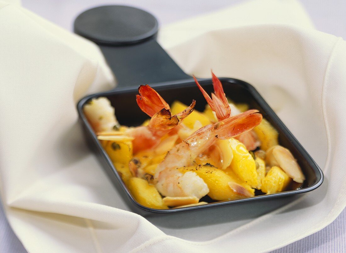 Shrimps with mango in raclette pan