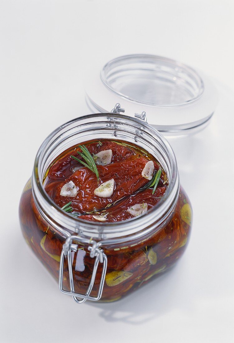 Getrocknete Tomaten mit Knoblauch und Rosmarin im Glas