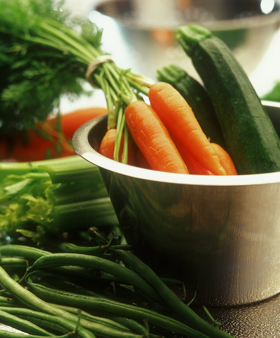 Carrots and courgettes in a dish, beans and celery