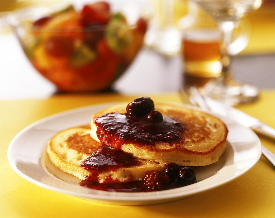 Two pancakes with berry and cherry sauce