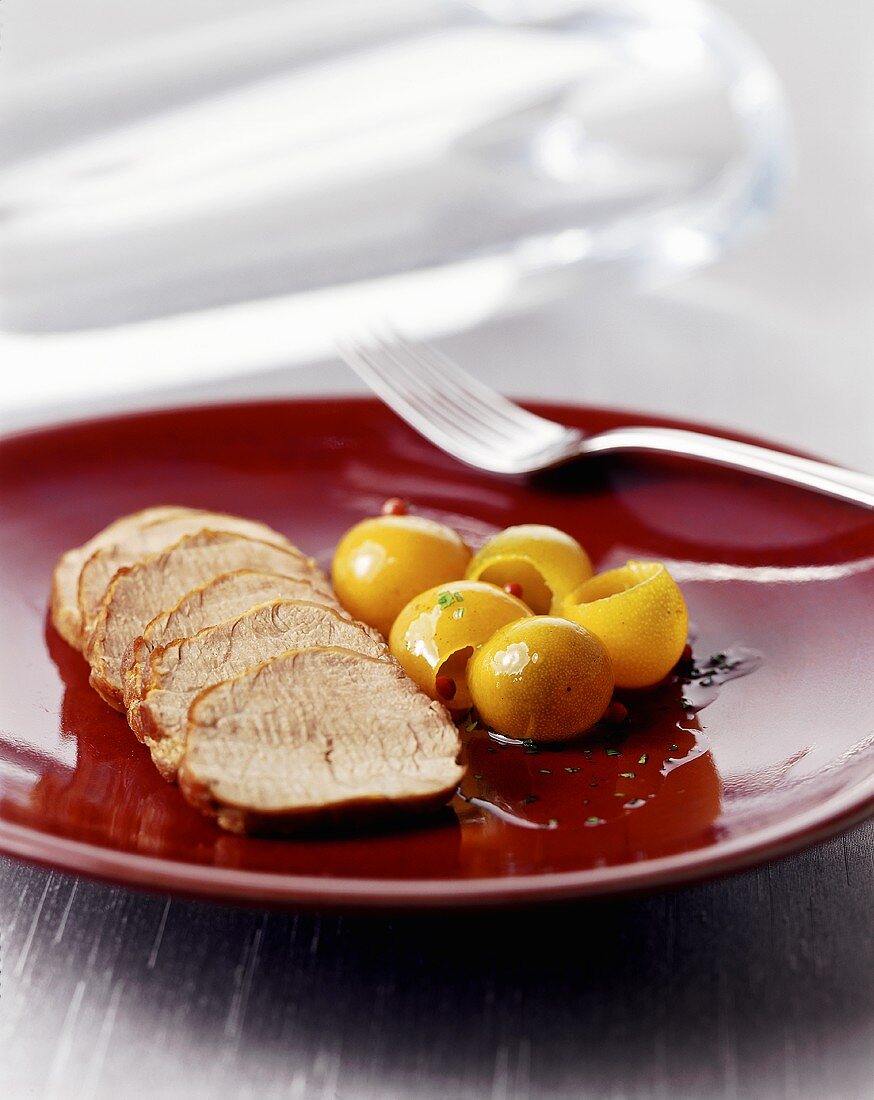 Carved loin of pork with kumquats