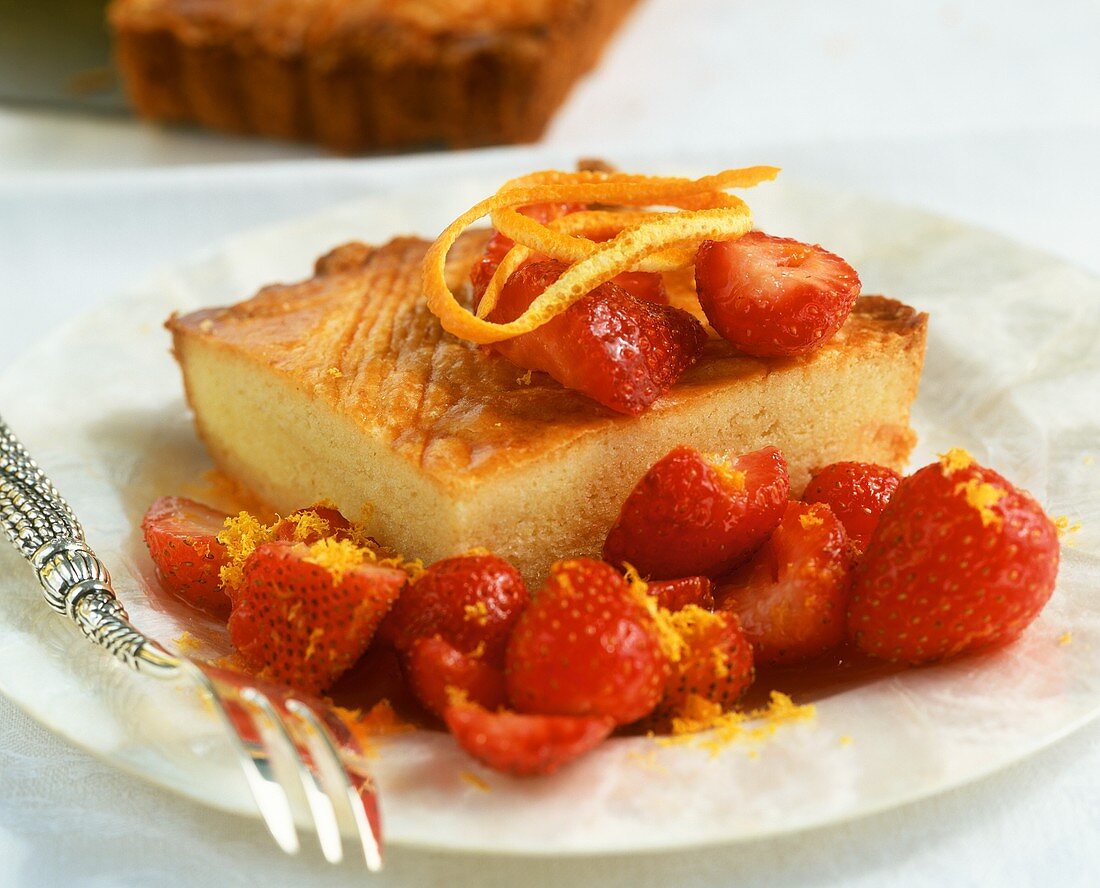 A piece of tray-baked butter cake with fresh strawberries