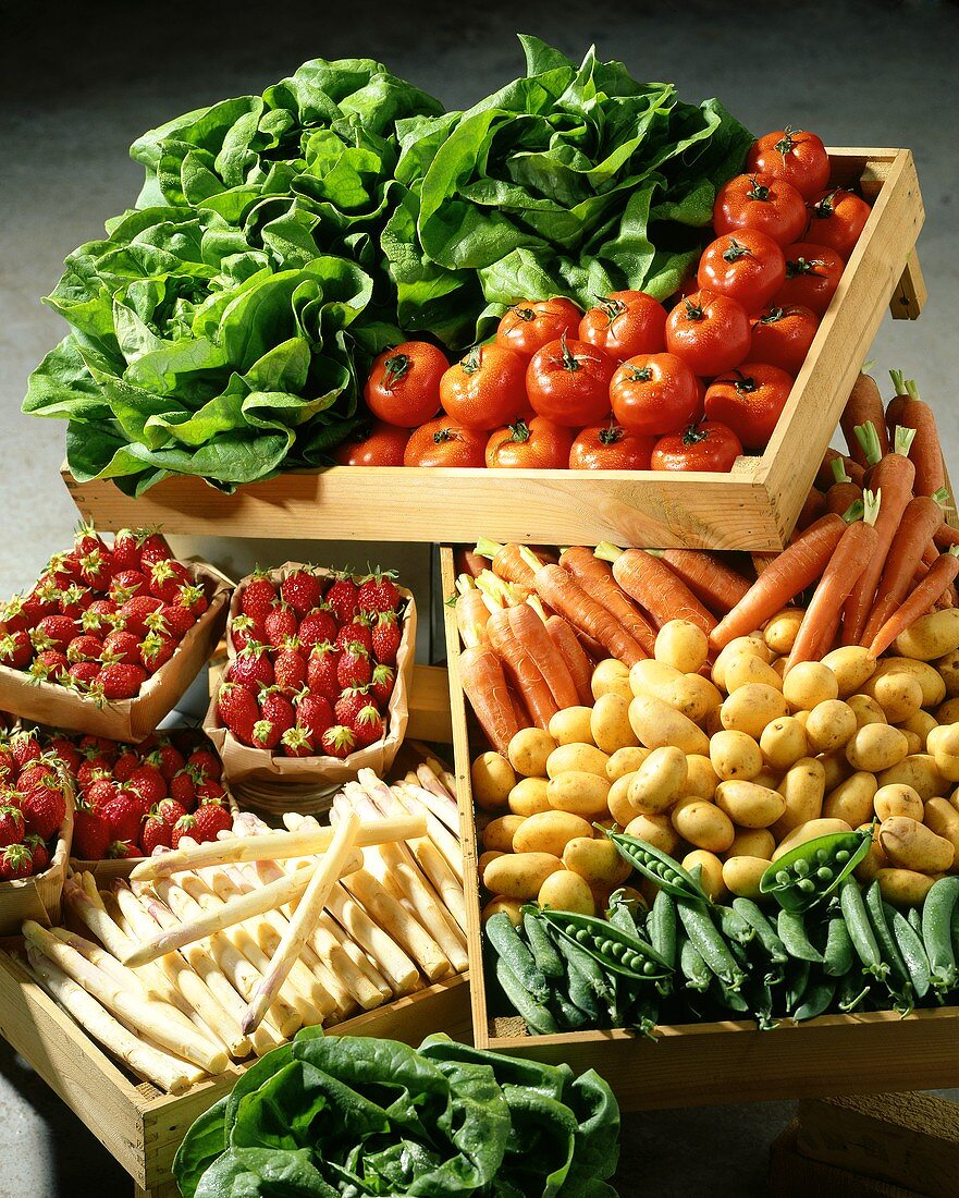 Fresh vegetables, lettuces and strawberries in wooden crates