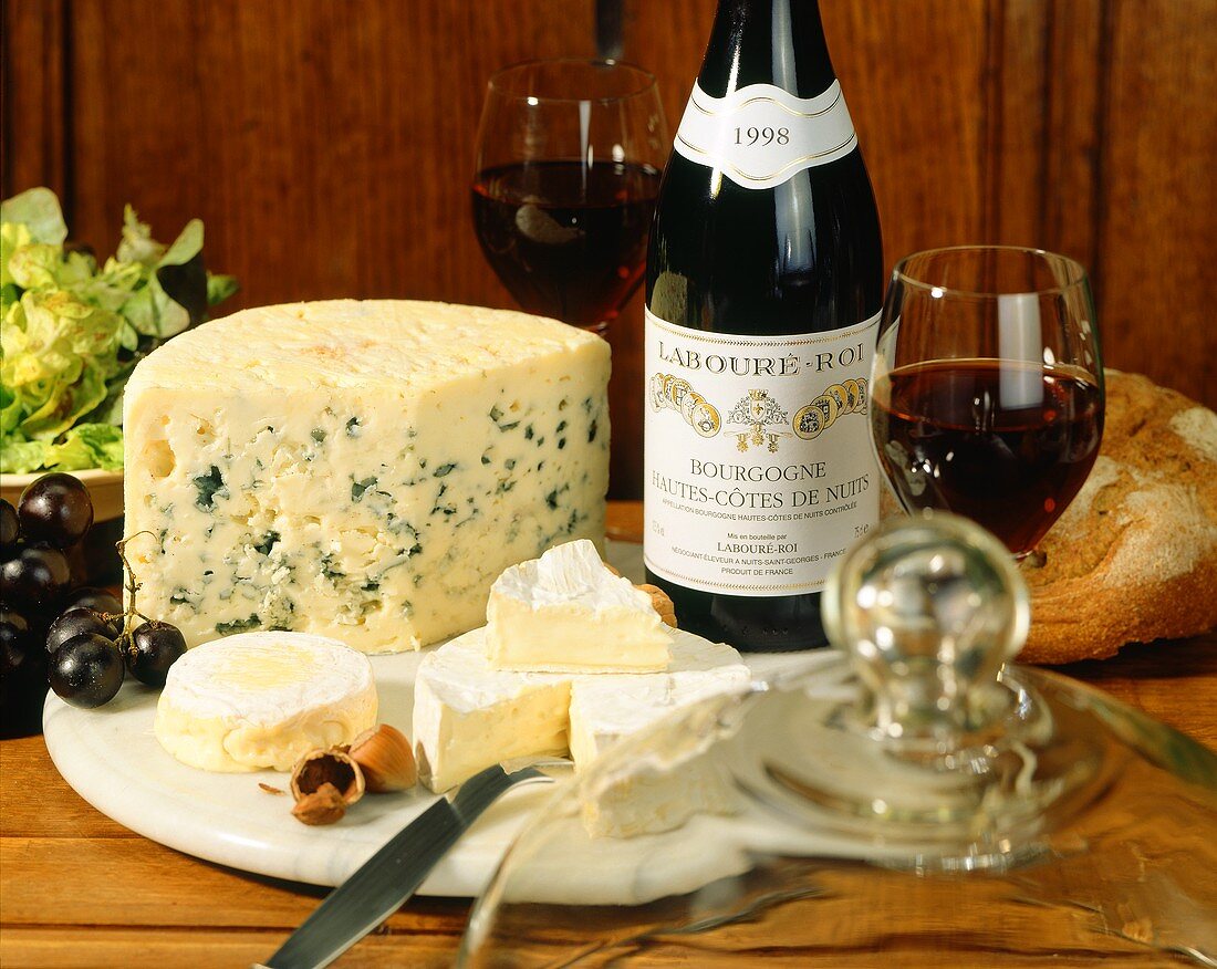 Käseplatte mit französischem Käse und Flasche mit Rotwein