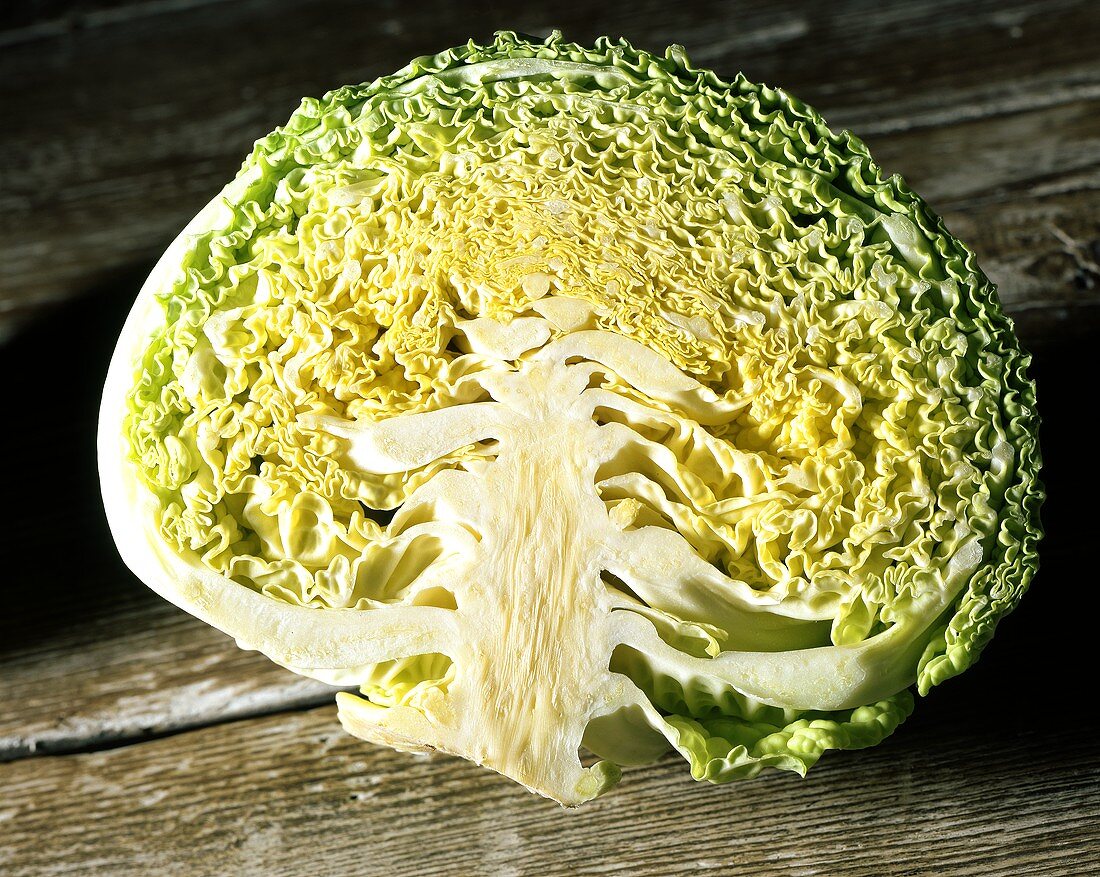White cabbage, halved on wooden background