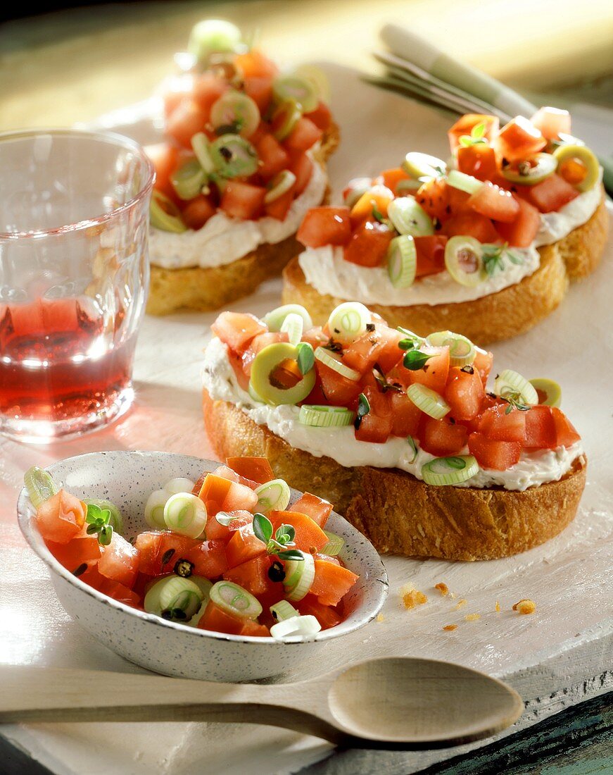 Weissbrotscheiben mit Frischkäse und Tomatenwürfeln