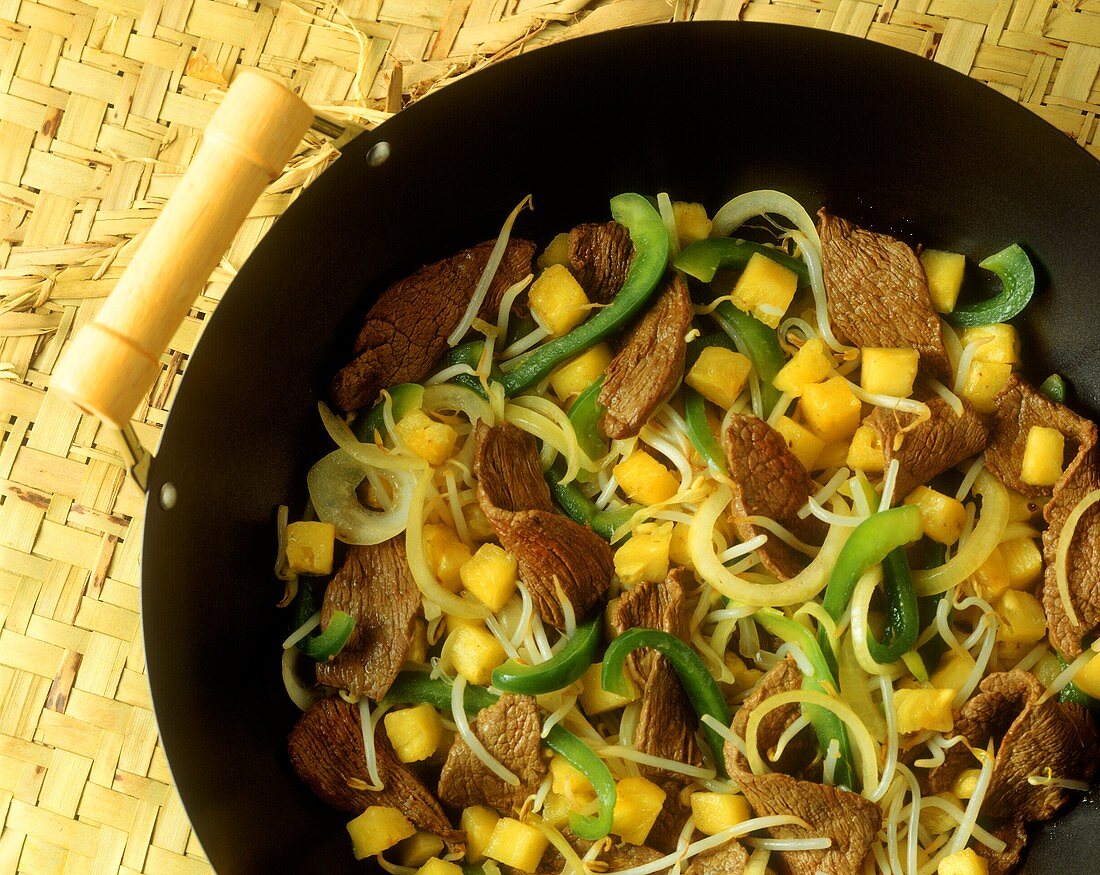 Asiatisches Wokgericht mit Rindfleisch, Paprika und Ananas