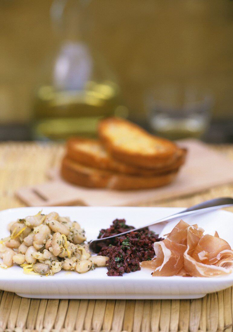 Tapas plate: beans with lime, olive tapenade, ham