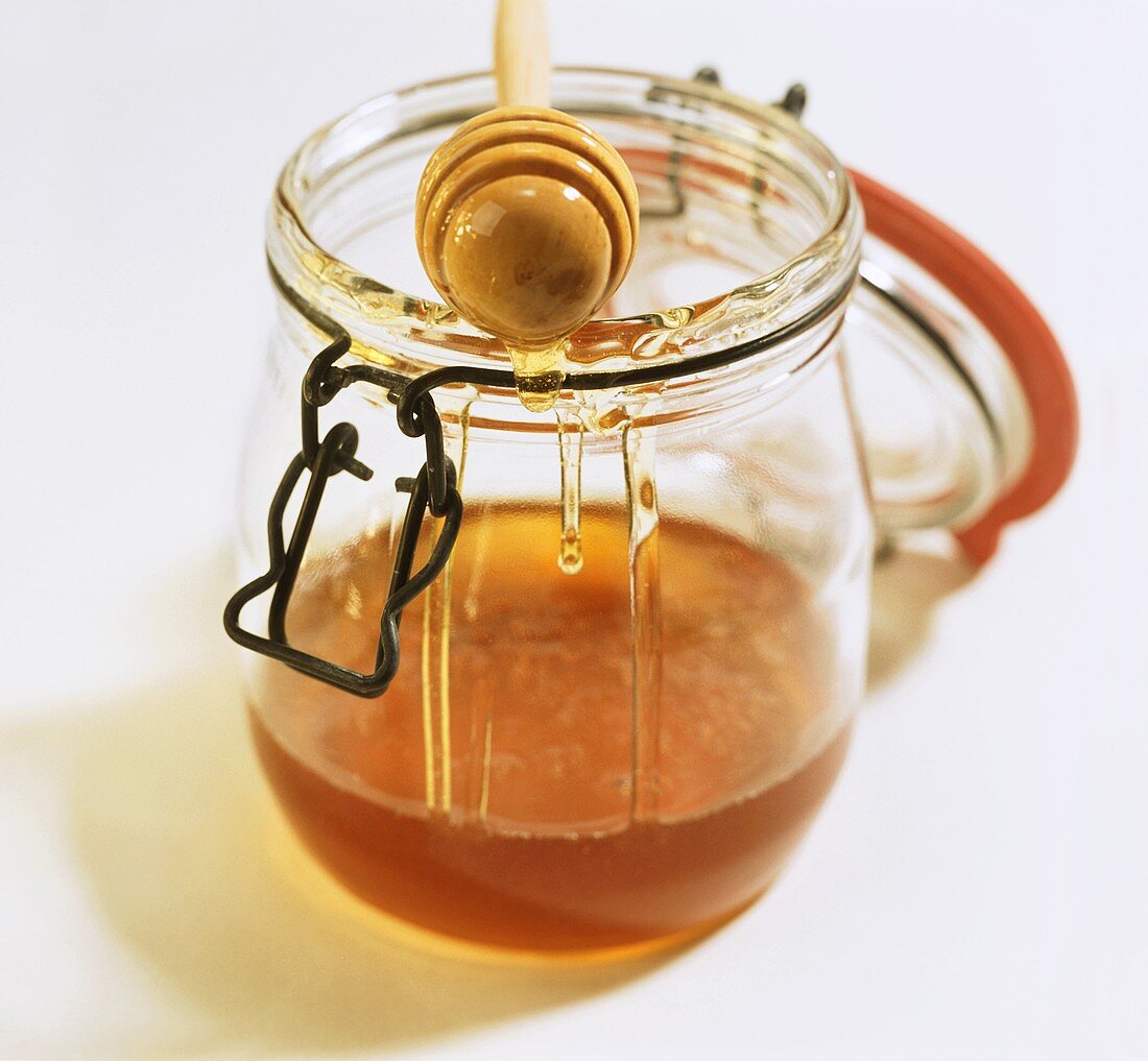 Honigheber auf Einmachglas mit Bienenhonig