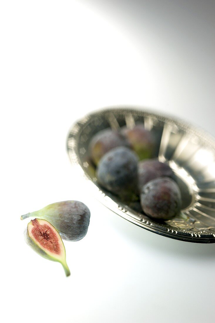 Figs in and in front of silver bowl