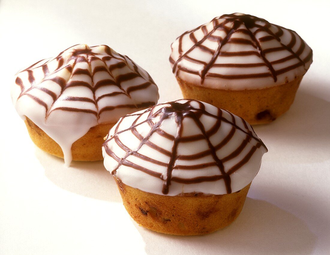 Drei Muffins mit Spinnenmuster-Zuckerguss