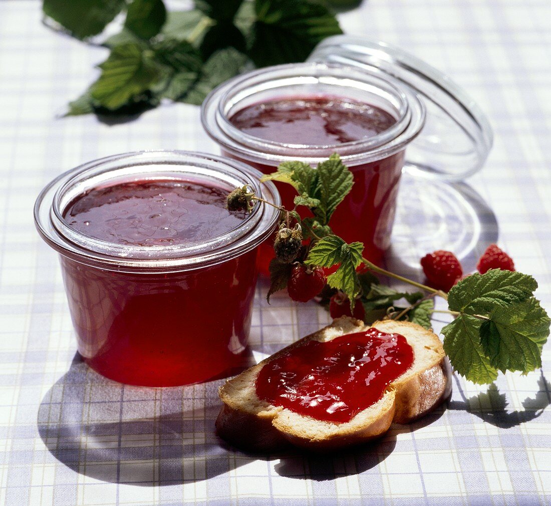 Raspberry jelly in jars and on slice of bread